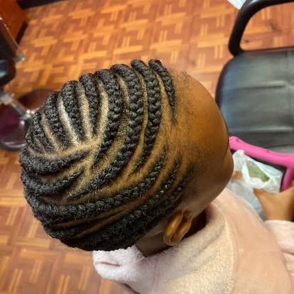 Close-up of braided cornrows on a child’s head in a salon chair