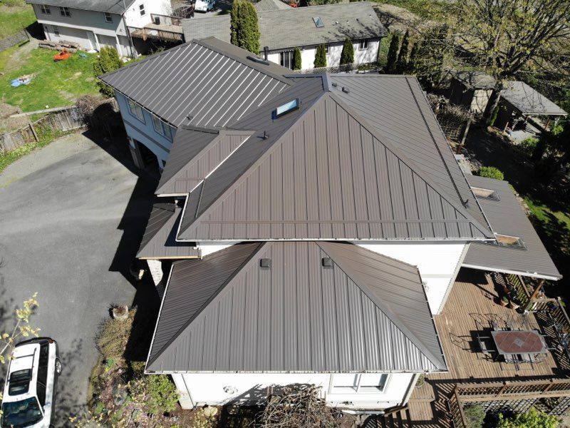 A single family home with a gray standing seam metal roof.