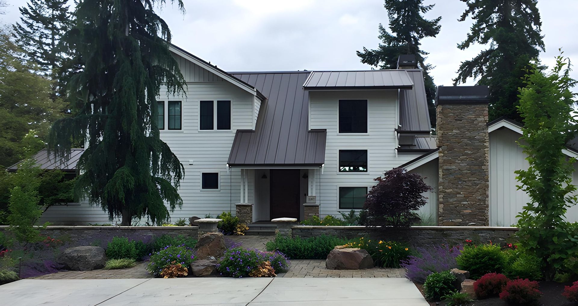 A modern two-story single family home with white siding and a metal roof.