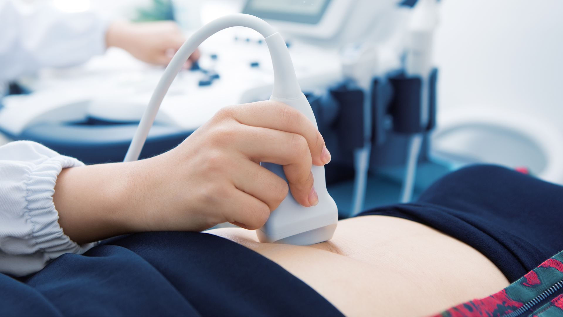 Ultrasound scan on a patient's abdomen; a medical professional uses a handheld device.