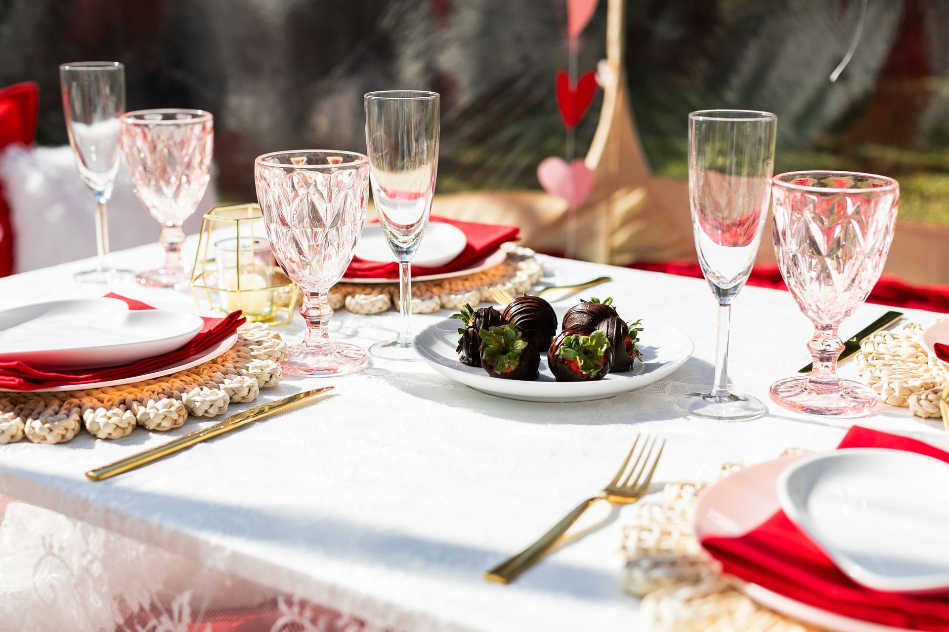 A table set for a valentine 's day dinner with a plate of strawberries on it.