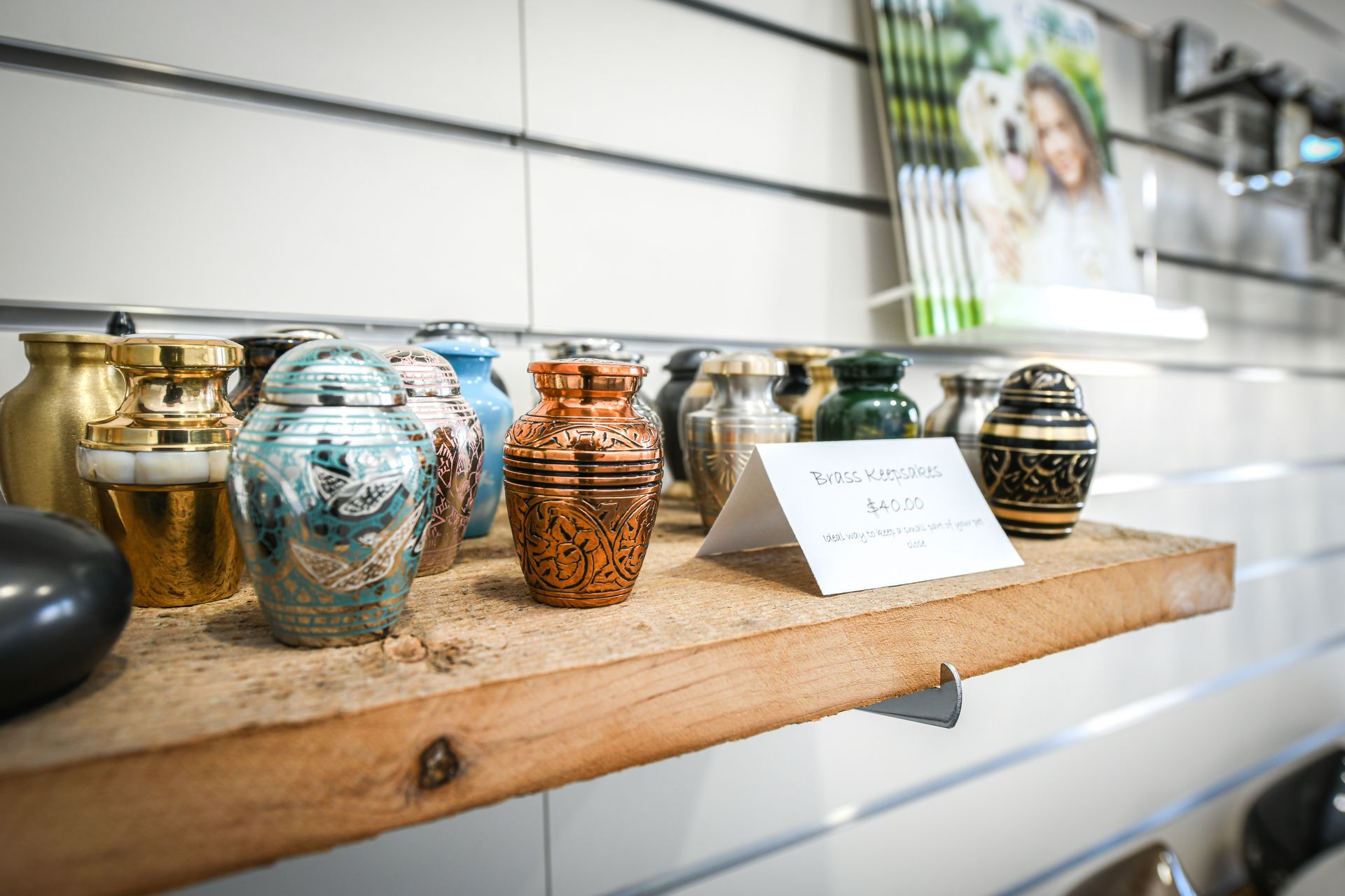 A shelf filled with urns and a card on it.