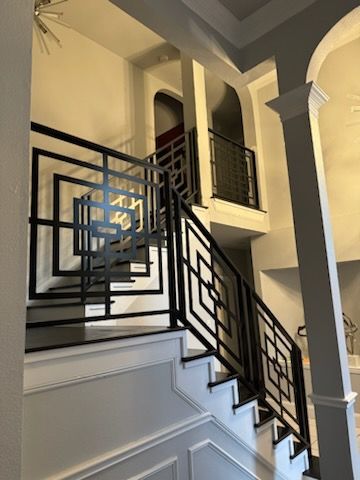 A staircase with a black railing in a house
