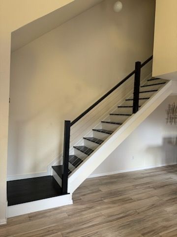 A white staircase with black steps and a black railing in a living room