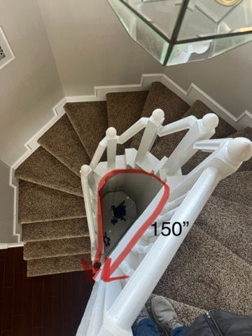 A picture of a spiral staircase with a red arrow pointing to the bottom of the stairs