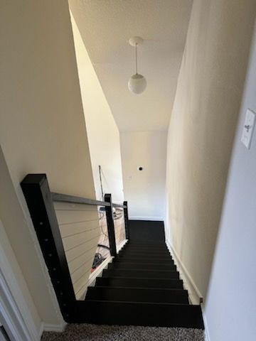 A black staircase leading up to the second floor of a house