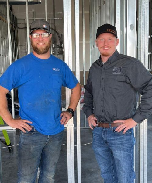 Two men standing next to each other with their hands on their hips