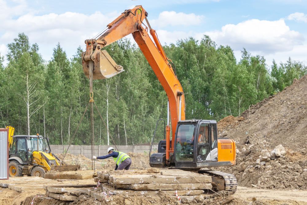 An Excavator Is Digging A Hole In The Ground At A Construction Site — JJ's Excavator & Tipper Hire in Murgon, QLD