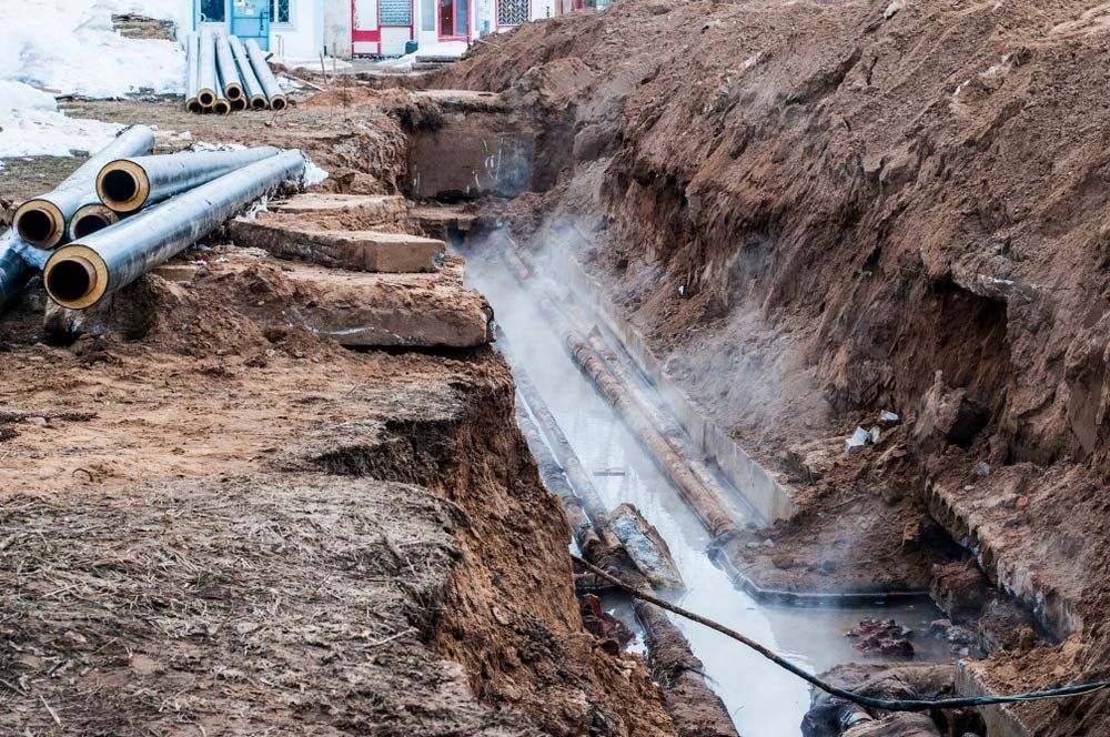 A Pipe Is Being Installed In A Trench In The Dirt — JJ's Excavator & Tipper Hire in Murgon, QLD