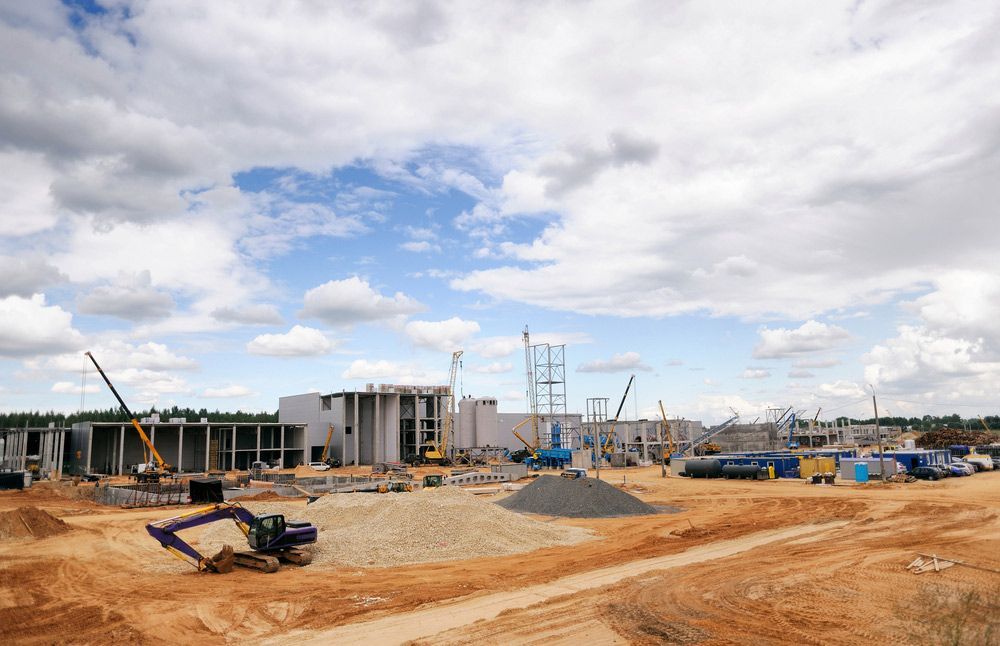 A Large Building Is Being Built On A Dirt Field — JJ's Excavator & Tipper Hire in Nanango, QLD