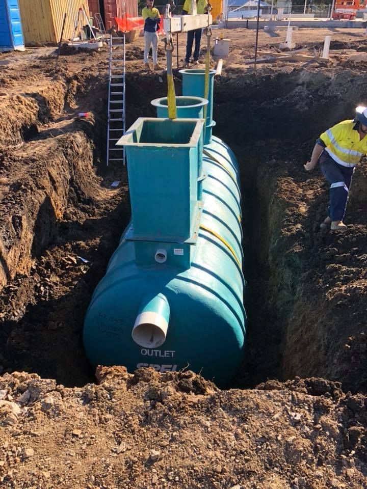 A Large Blue Tank Is Sitting In A Hole In The Ground — JJ's Excavator & Tipper Hire in Kingaroy, QLD