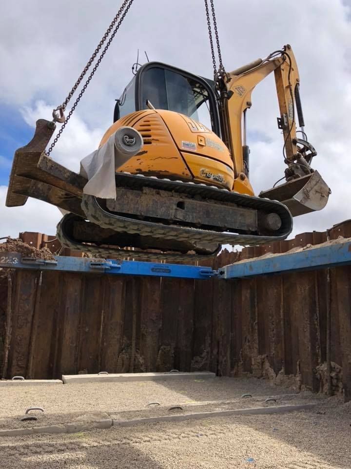 A Yellow Excavator Is Being Lifted By A Crane — JJ's Excavator & Tipper Hire in Nanango, QLD