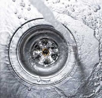 Running water drains down a stainless steel sink
