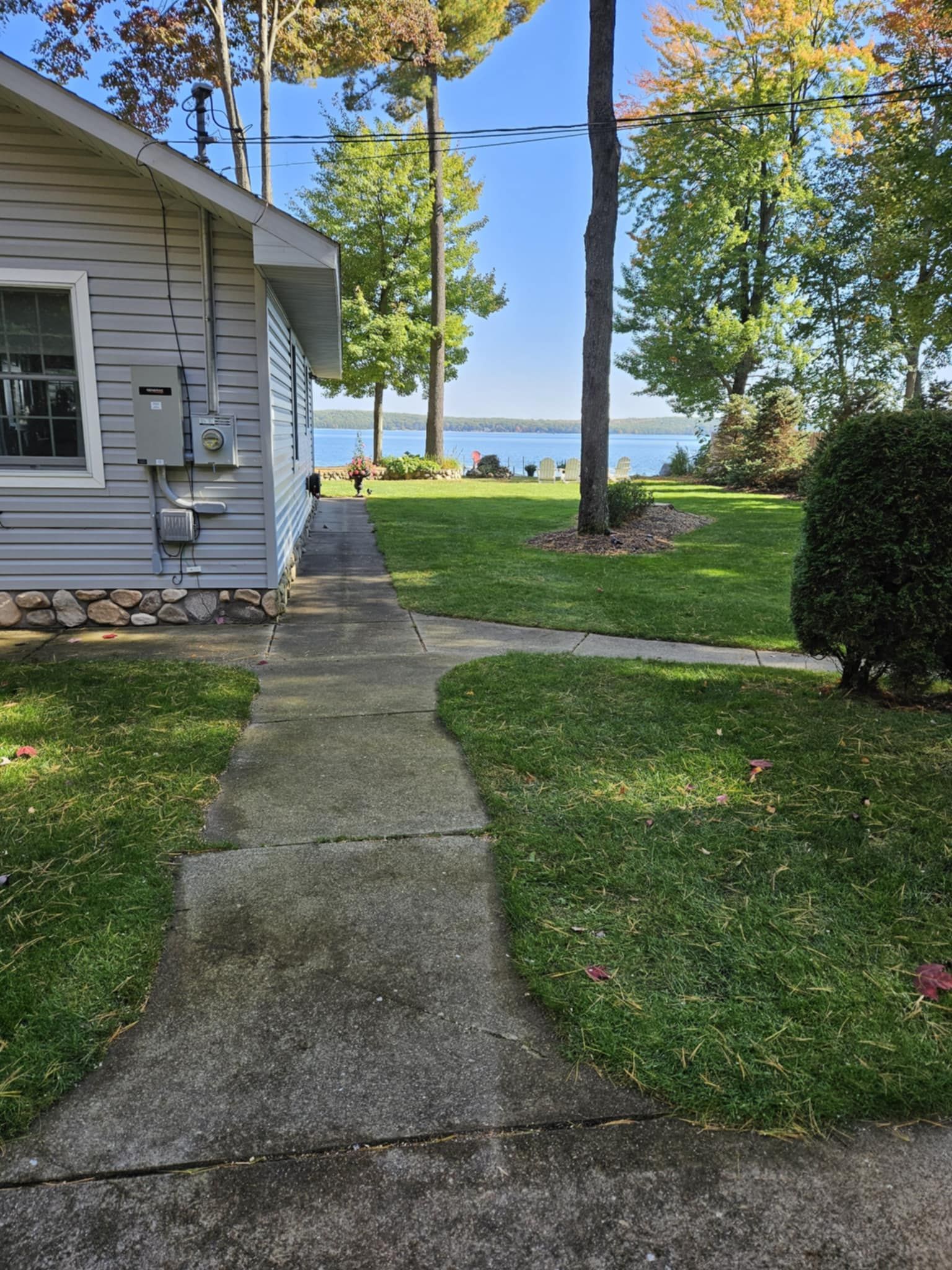 A path leading to a house with a view of a lake.