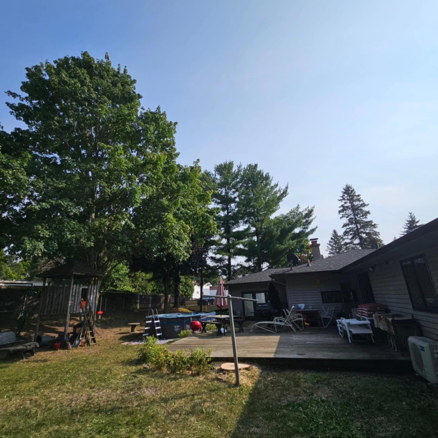 The backyard of a house with a deck and trees