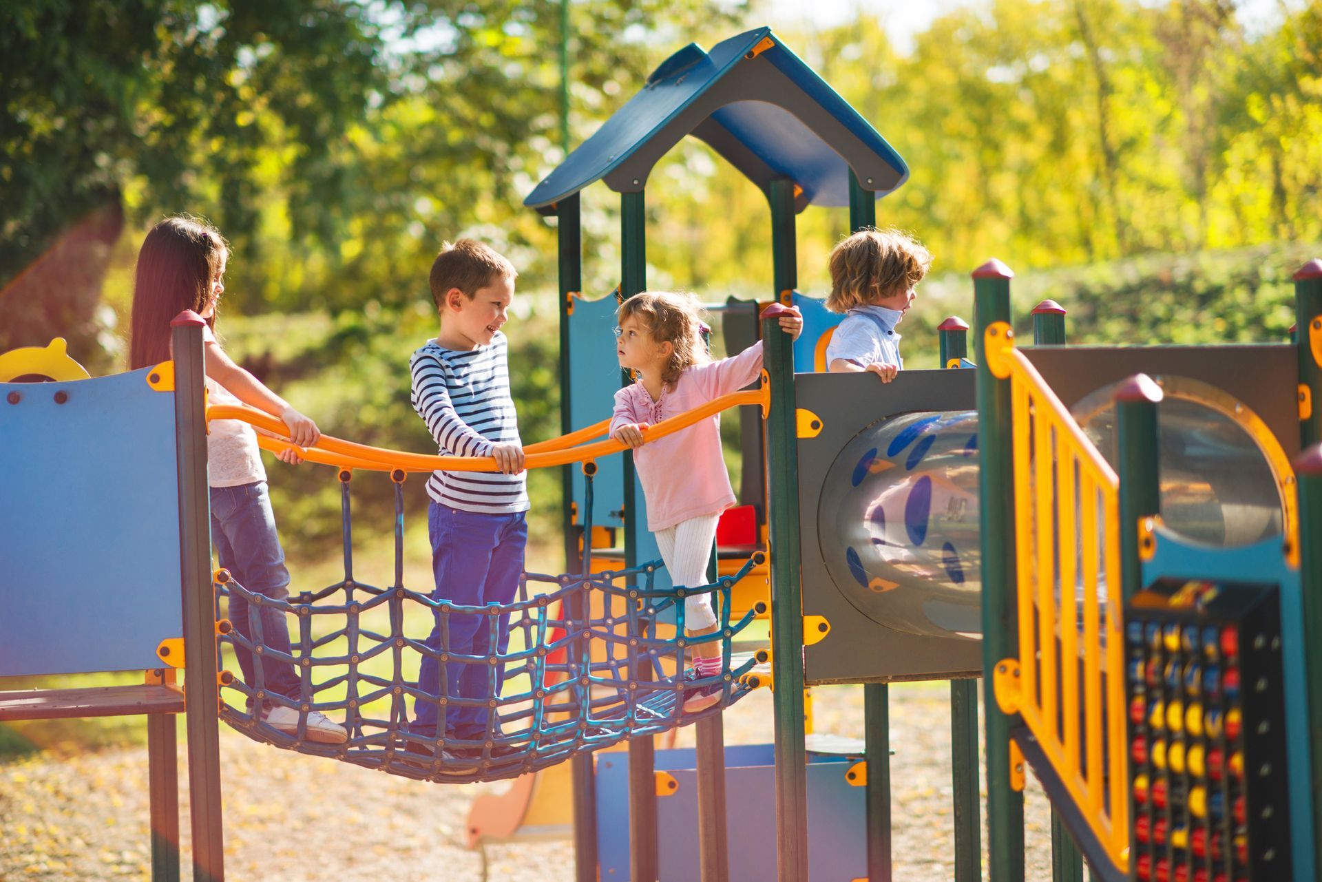 A group of children are playing on a playground in a park.