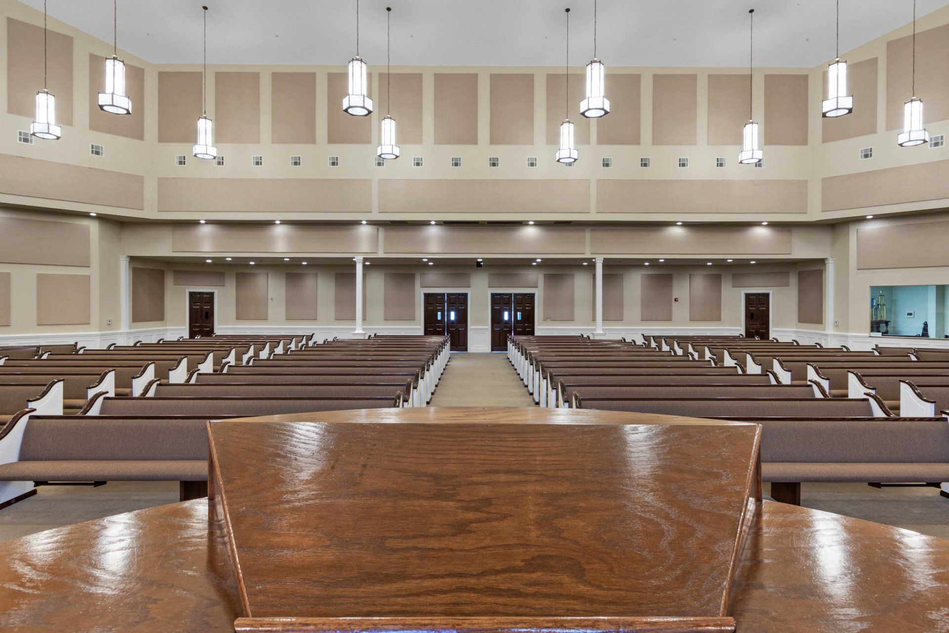 Interior of a church sanctuary with rows of pews facing a wooden pulpit.