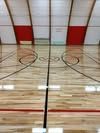 A basketball court with a wooden floor in a gym.