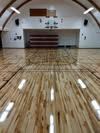 A basketball court with a wooden floor in a gym.