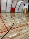 A basketball court with a wooden floor in a gym.
