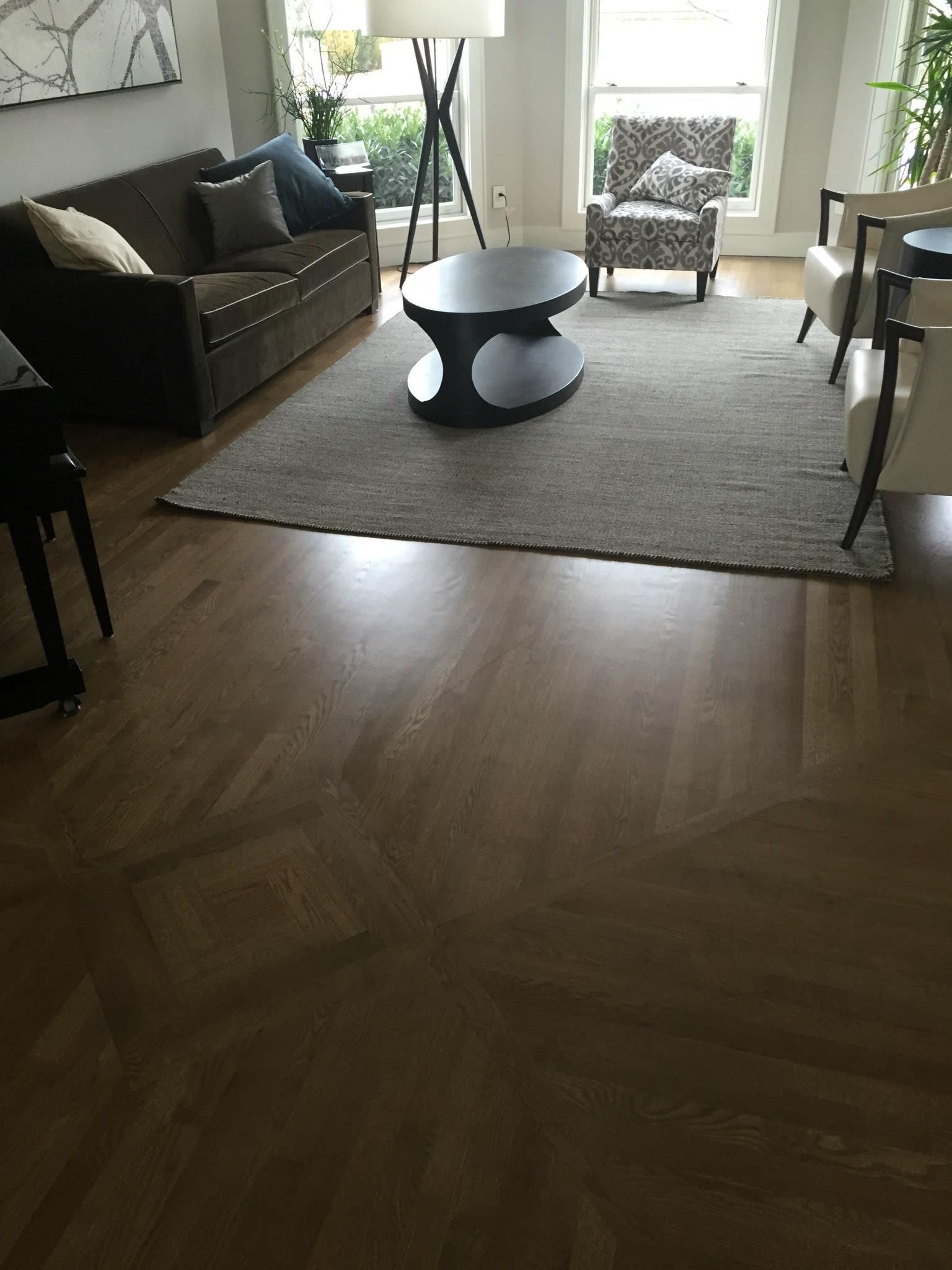 A living room with a couch , chair , coffee table and rug.