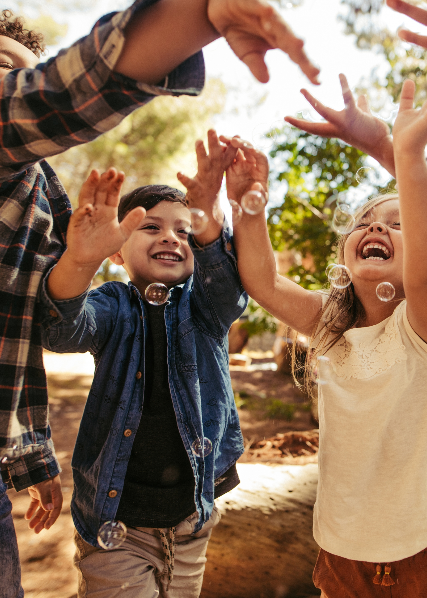 A group of children laying on the floor with their arms up in the air or in their mouth.