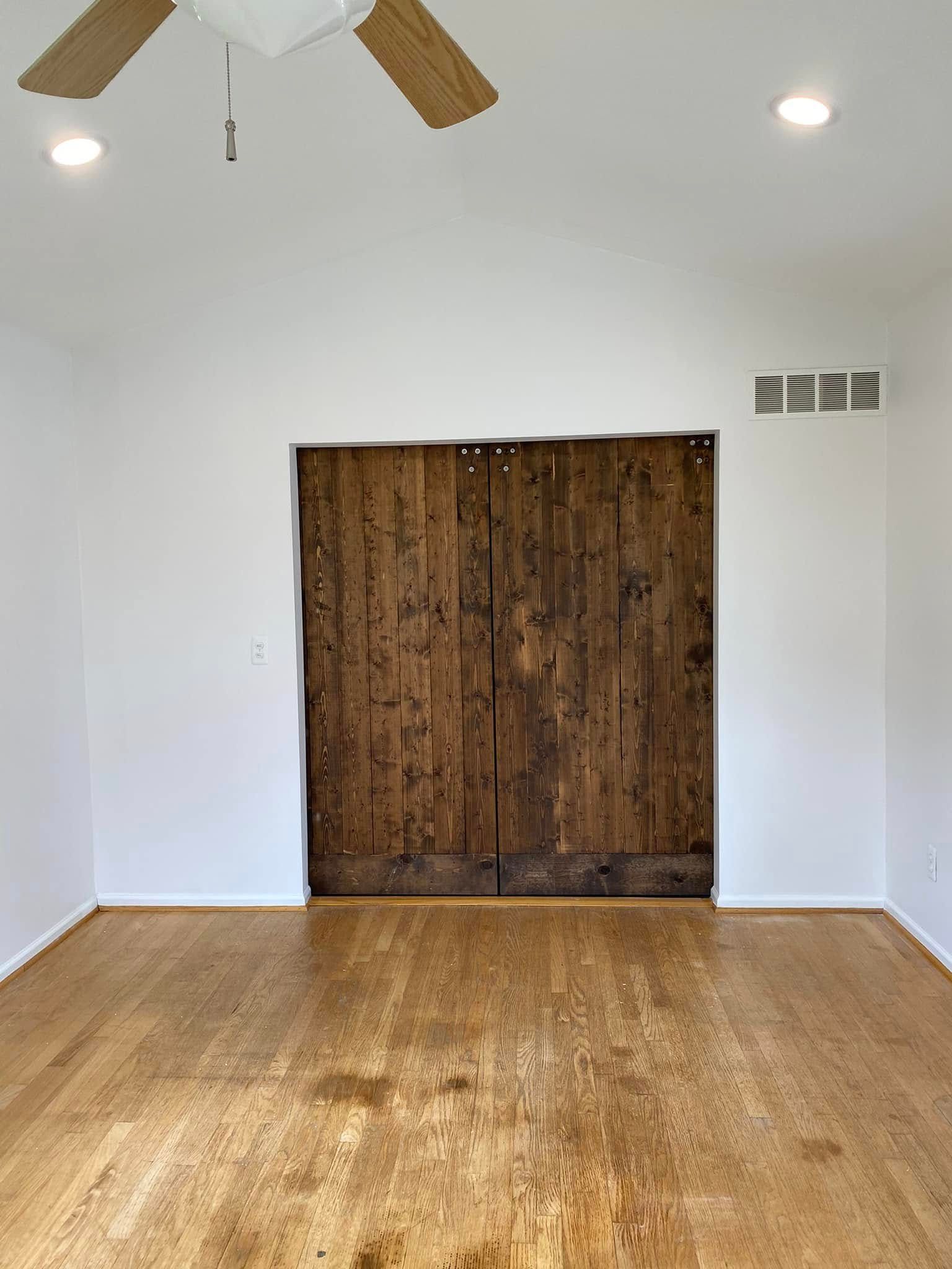 An empty living room with hardwood floors and a ceiling fan.