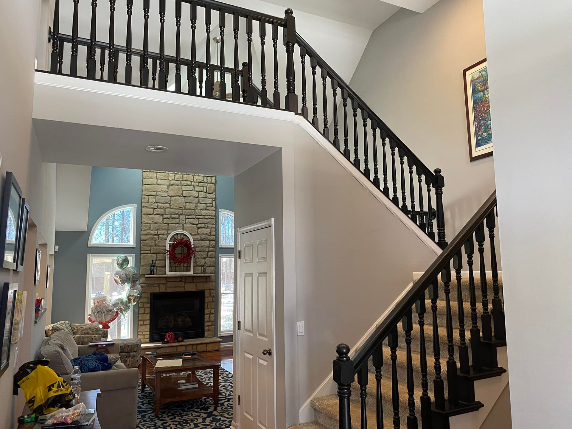 A living room with a fireplace and stairs leading up to the second floor.