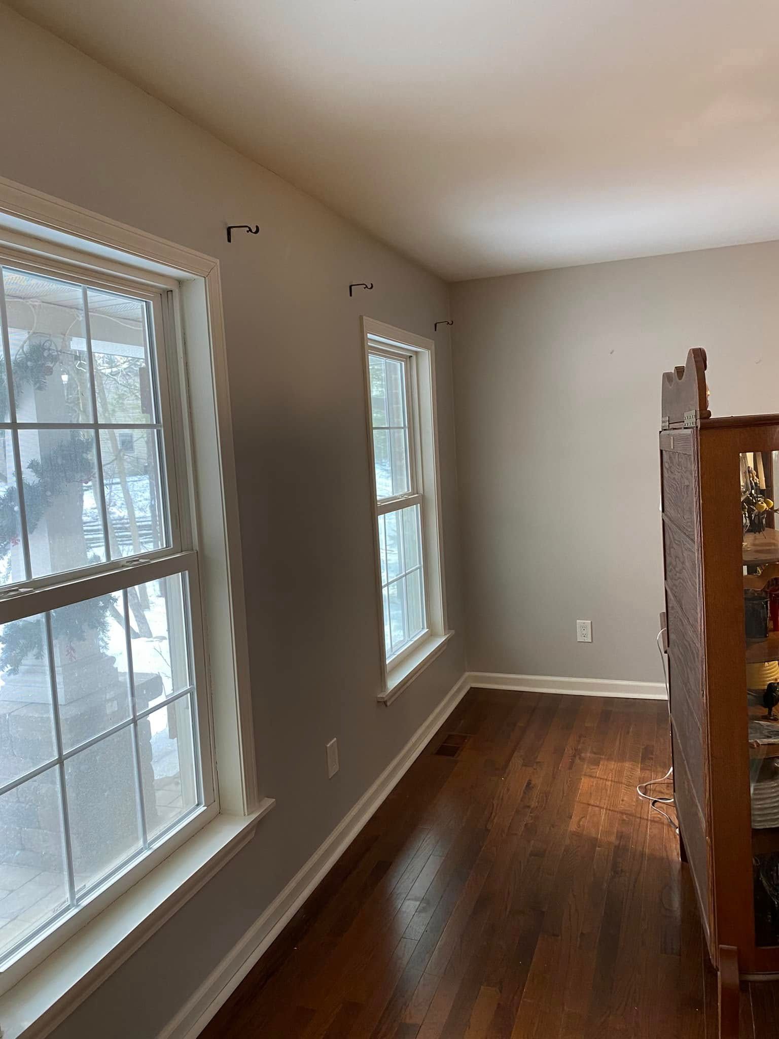 A living room with hardwood floors and lots of windows.