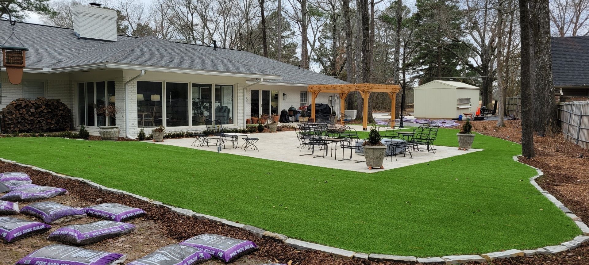 the backyard of a house with a lush green lawn and a patio .