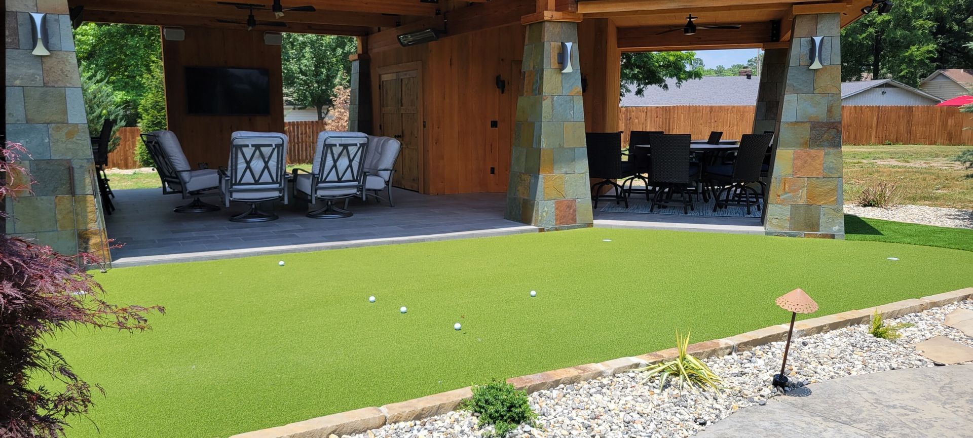 A patio with a dining table and chairs under a gazebo.