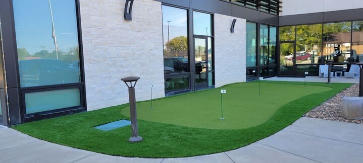 There is a putting green in front of a building.
