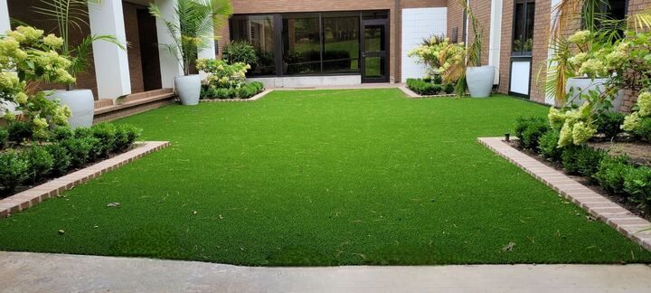 A large lush green lawn in front of a house.