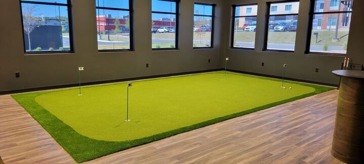 There is a putting green in the middle of the room.