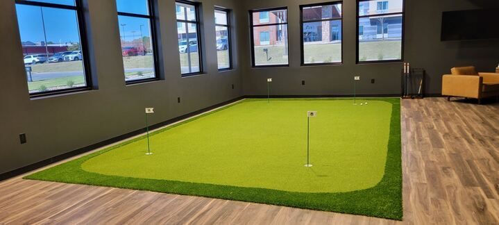 There is a putting green in the middle of the room.