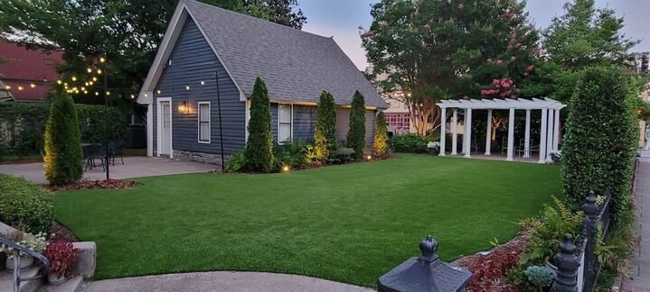 A small house with a large lawn in front of it.