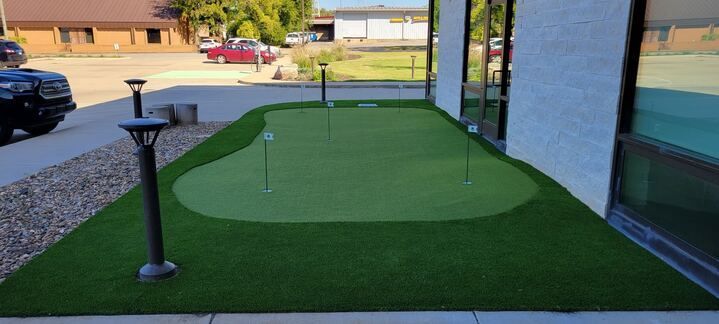 There is a putting green in front of a building.