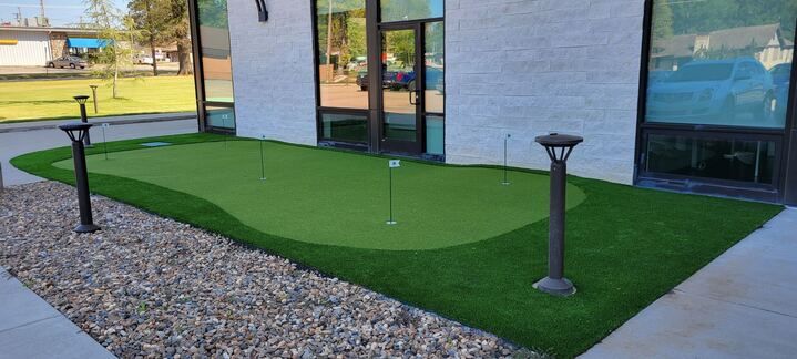 There is a putting green in front of a building.