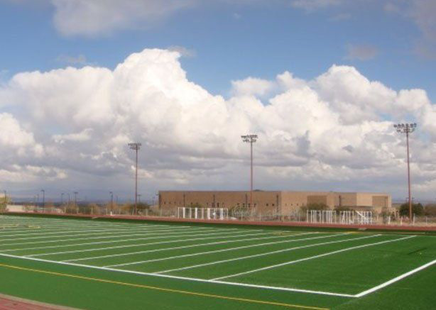 A football field with a blue sky and clouds in the background