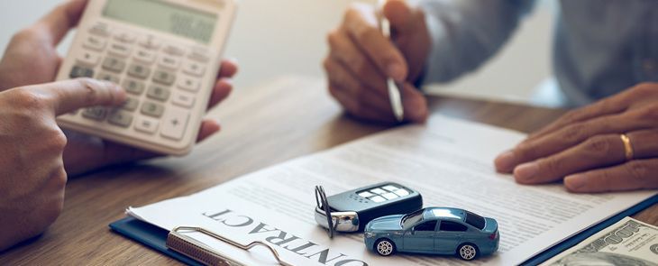 uma pessoa está sentada a uma mesa usando um laptop e um telefone celular.