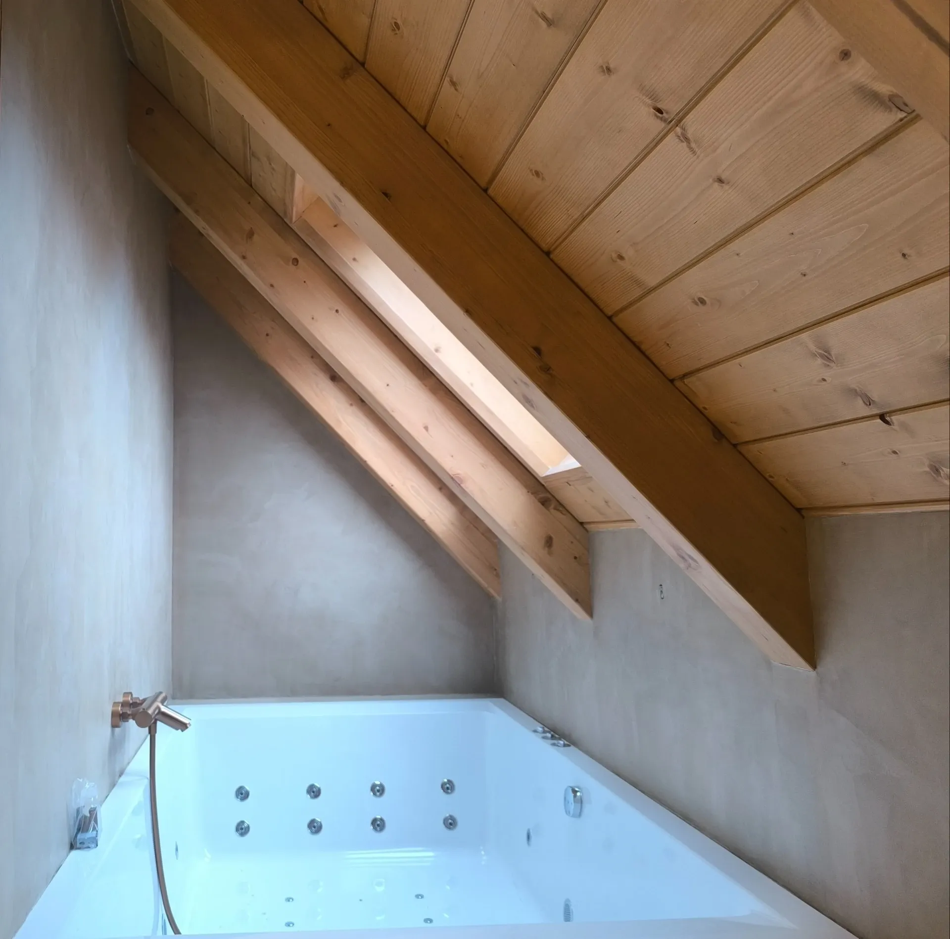 Baño con vigas de madera vistas y acabado claro