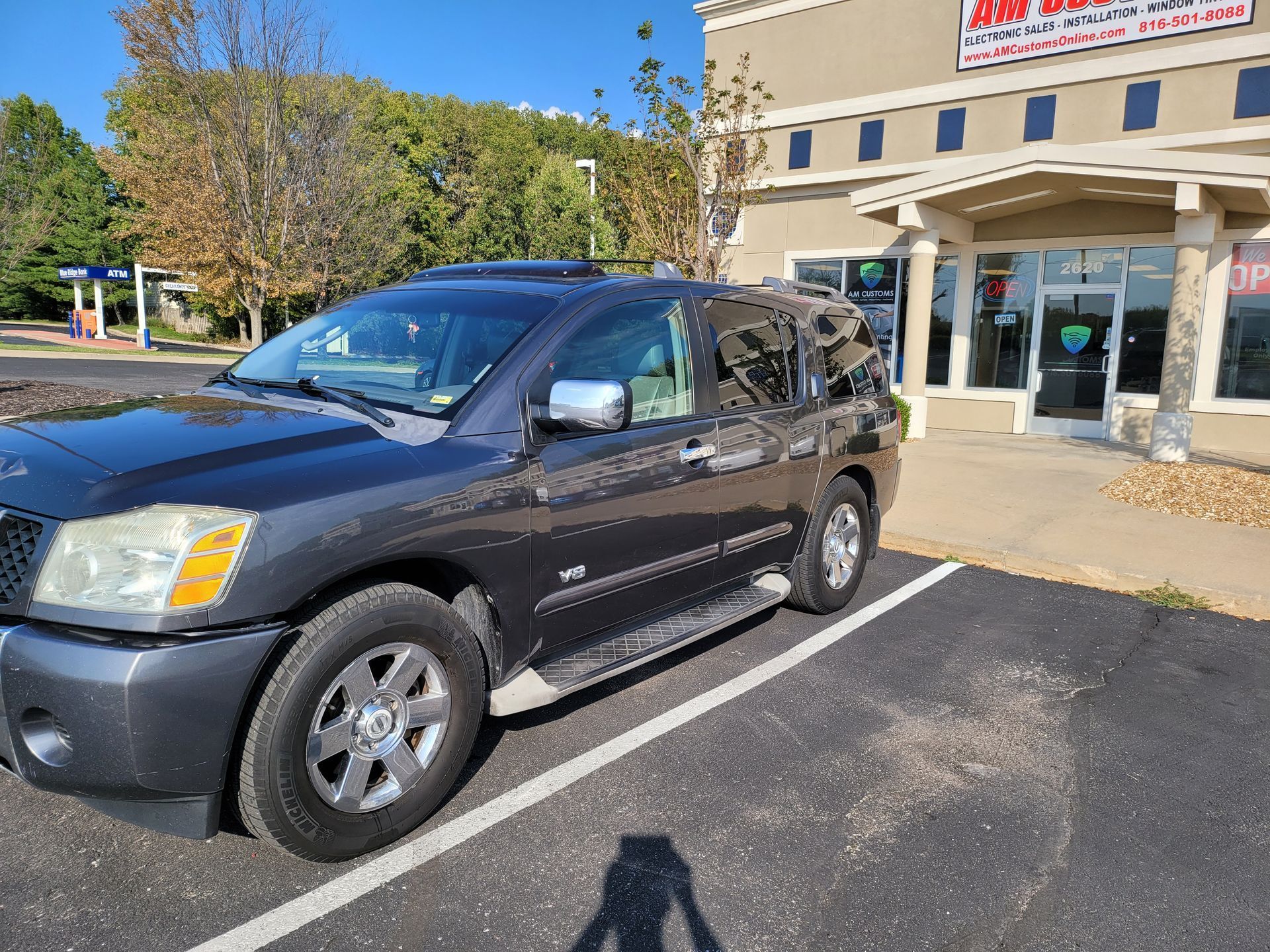 A black suv is parked in a parking lot in front of a building.