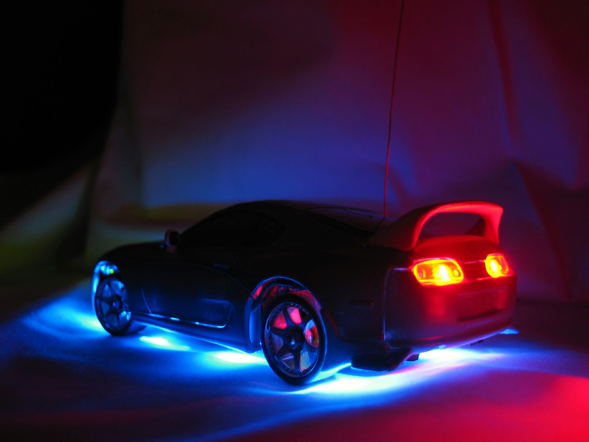 A remote control car is lit up with blue and red lights.