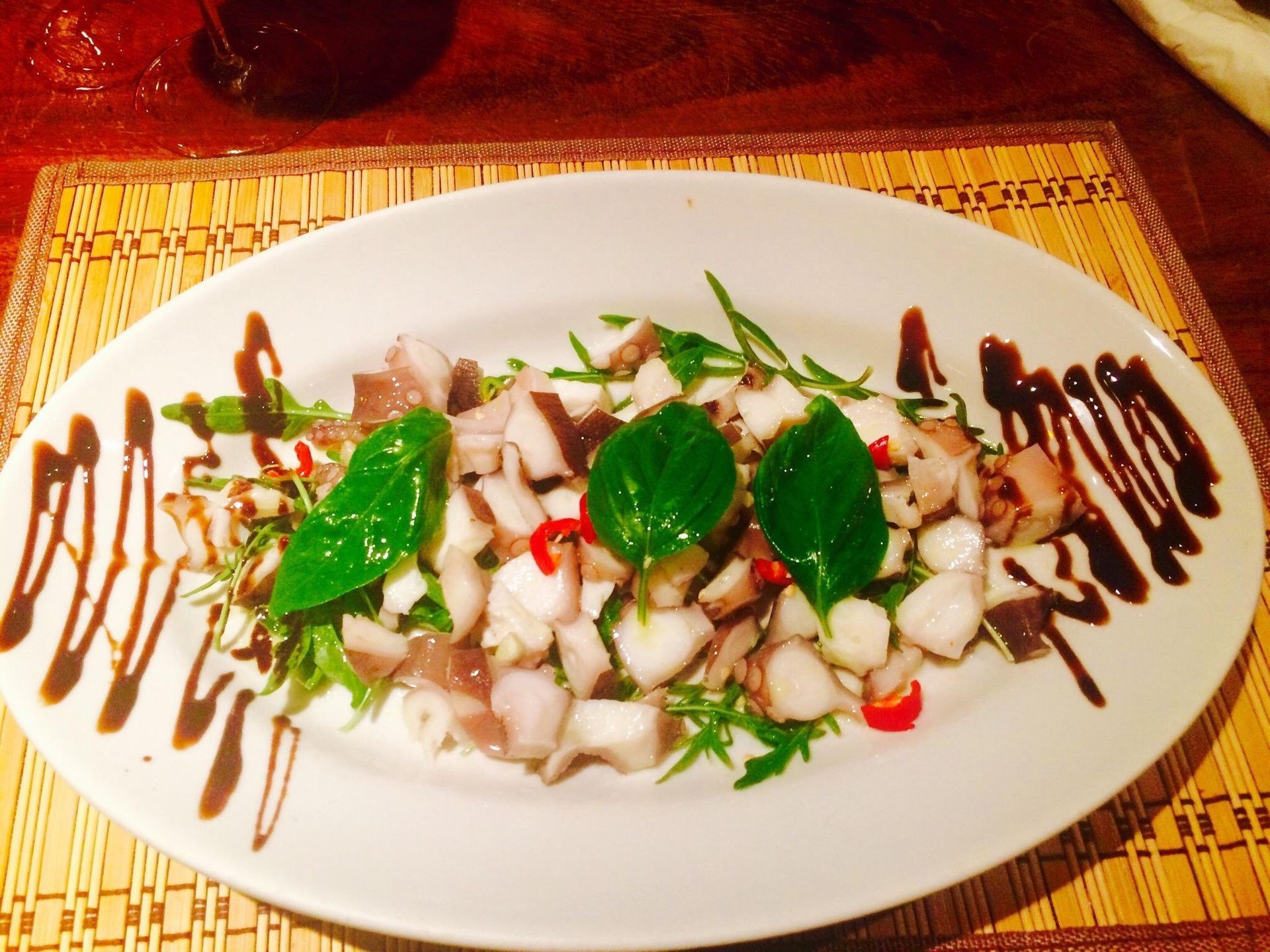 Un piatto bianco con un'insalata sopra su un tavolo