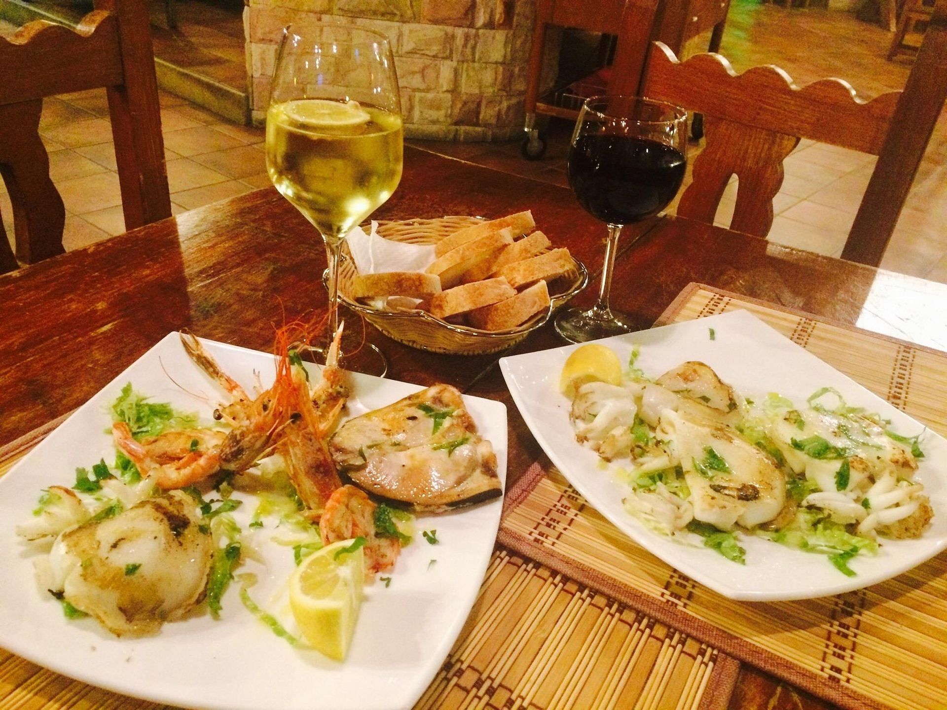 Due piatti di cibo e un bicchiere di vino su un tavolo