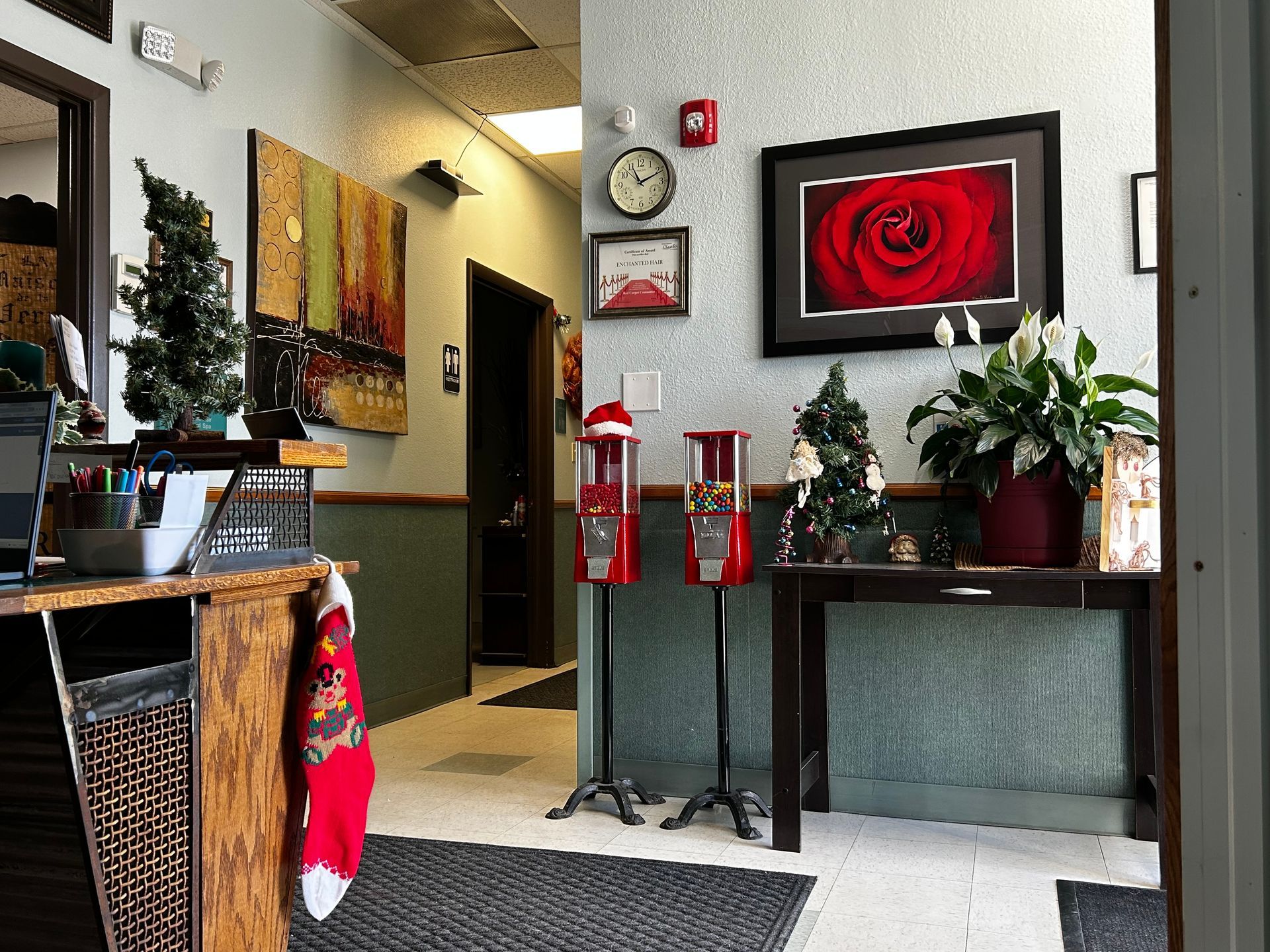 A room with a clock on the wall and a red rose on the wall