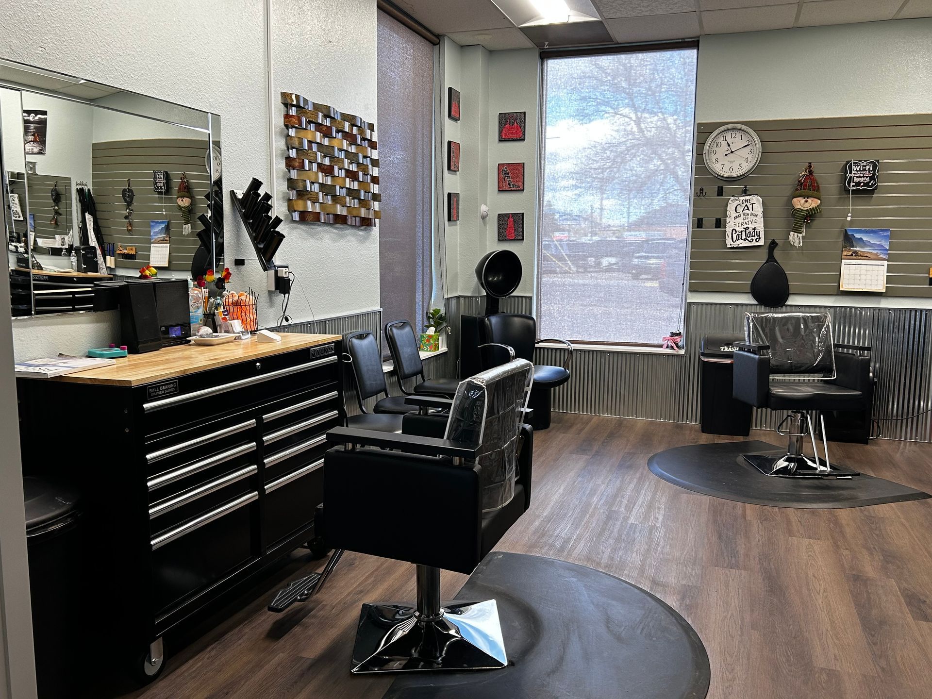 A salon station with a lot of chairs and a clock on the wall.