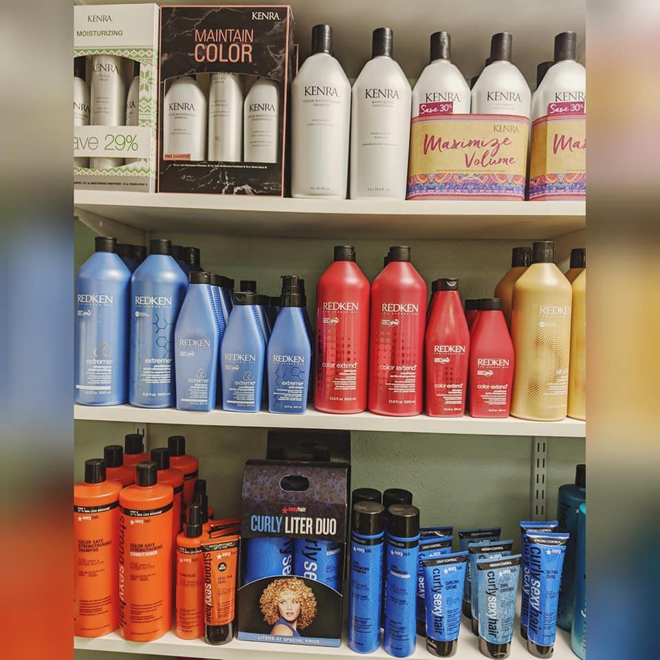 A shelf full of hair products including redken