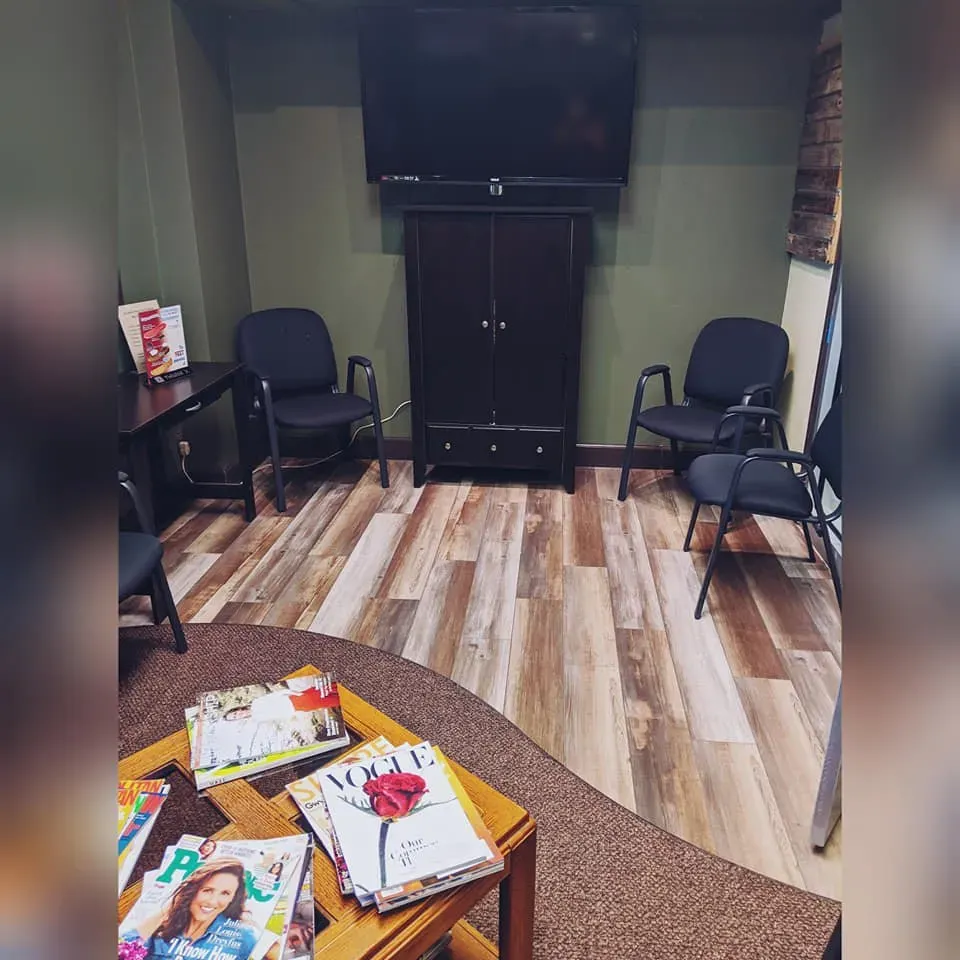 A waiting room with a stack of magazines on a table