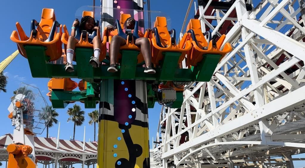 A group of people are riding a roller coaster at an amusement park.